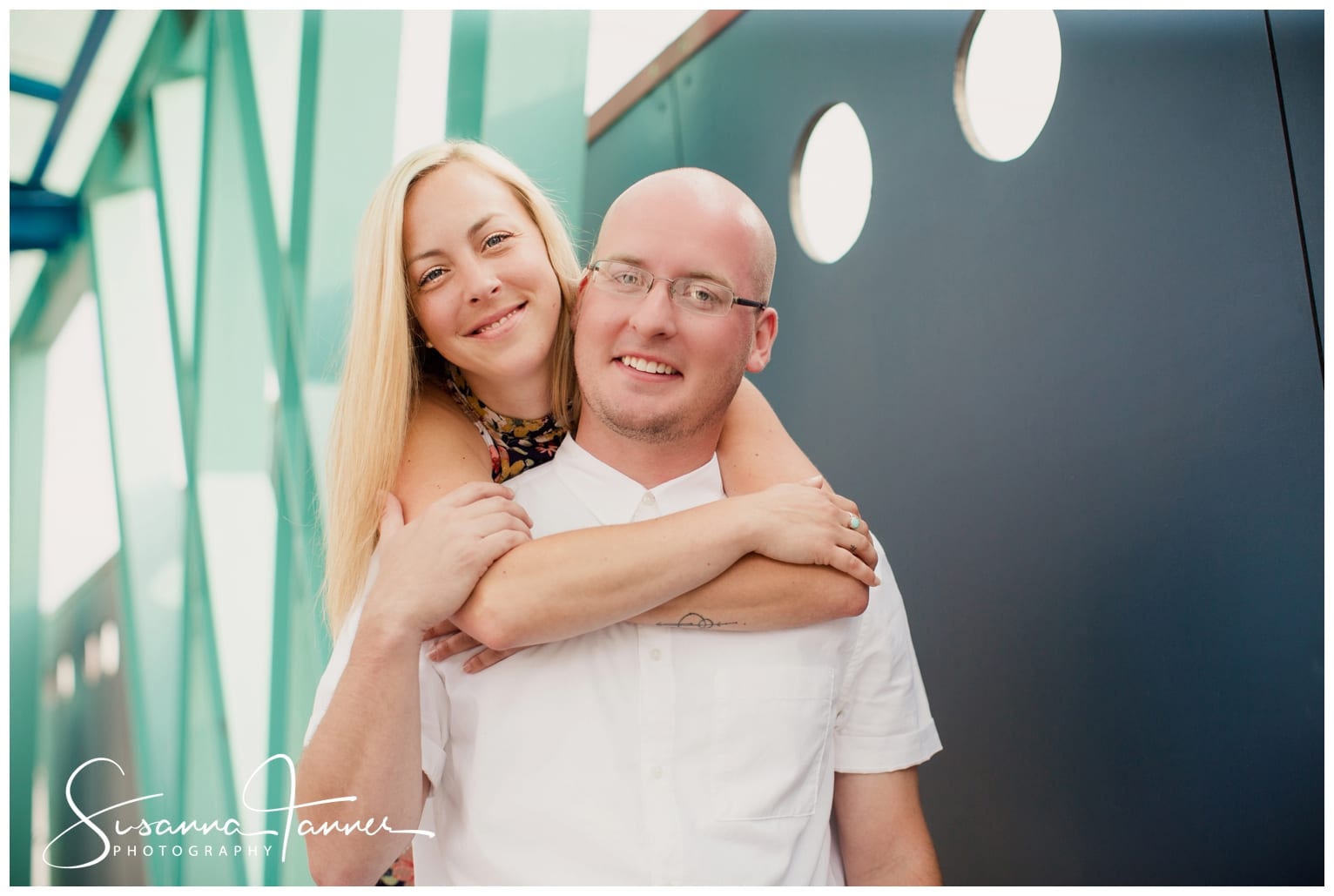 Fountain Square Indianapolis Photography Engagement Session female standing behind male with arms around him smiling