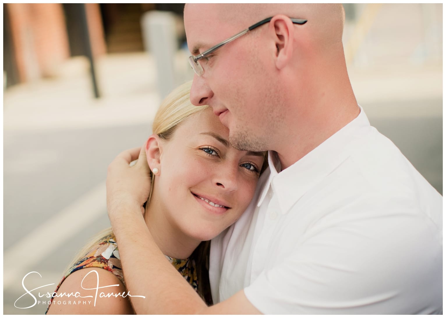 Fountain Square Indianapolis Photography Engagement Session male holding female close, her head on his chest and his arm around her