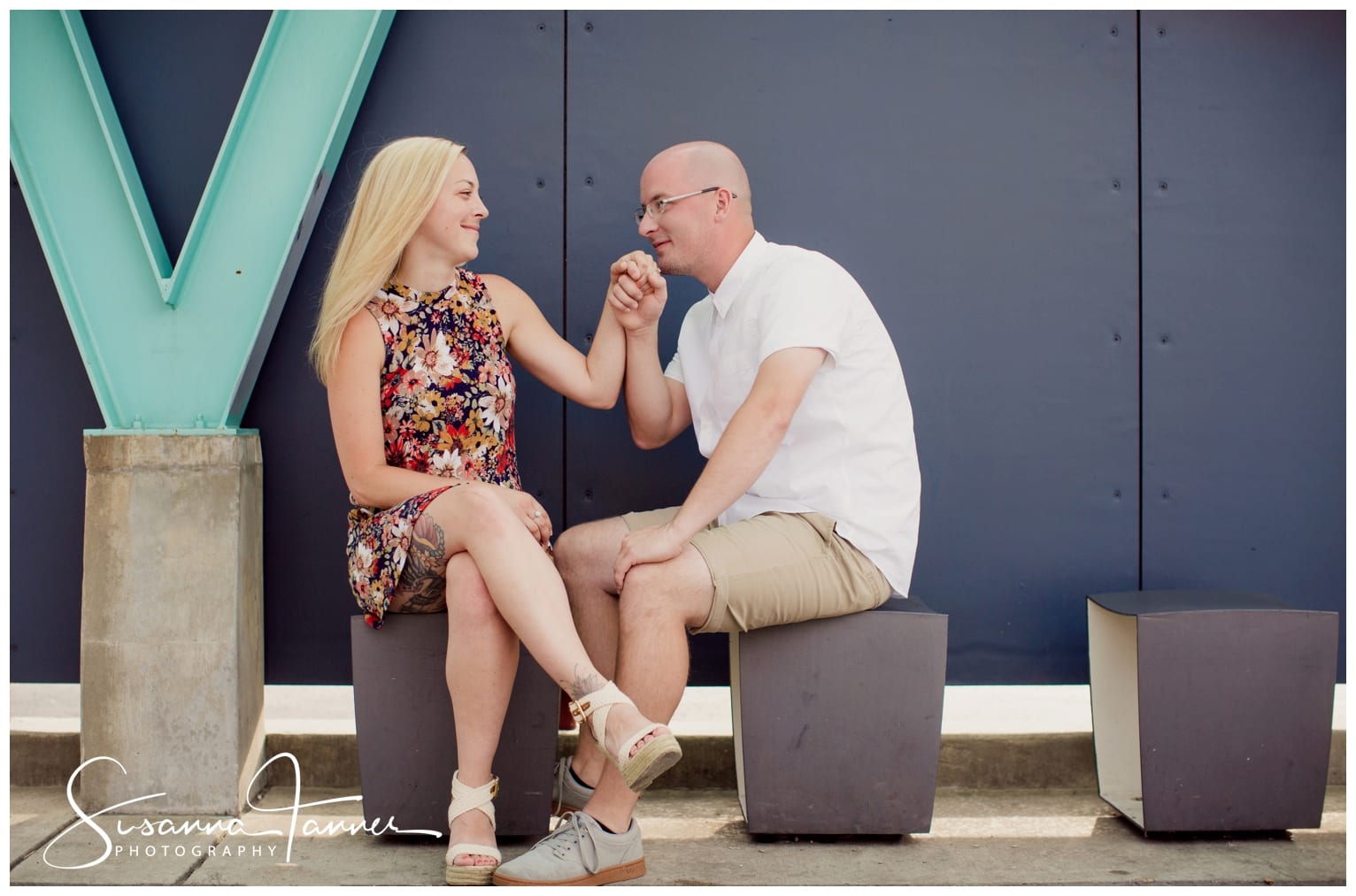 Fountain Square Indianapolis Photography Engagement Session male about to kiss female's hand while she looks adoringly at him