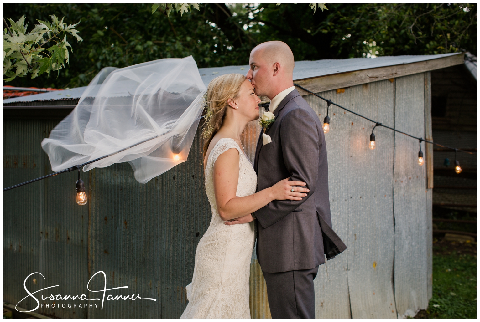 Indianapolis Outdoor Wedding, groom kissing bride's forehead while wind is blowing her veil