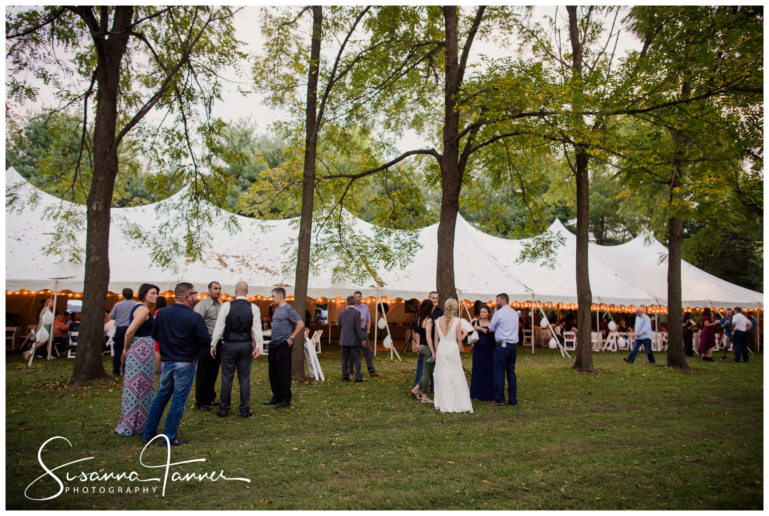 Indianapolis Outdoor Wedding, photo of large white topped tent in backyard for reception. People standing around talking.