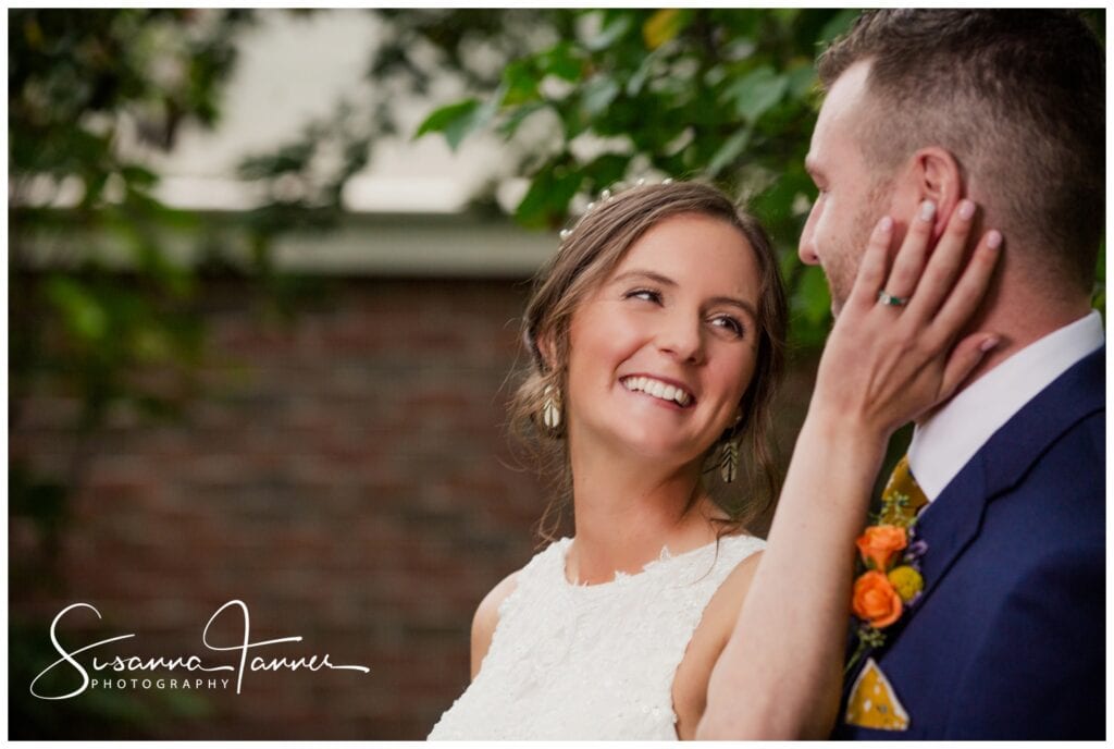 The Transept, Taft Museum of Art gardens, Cincinnati Ohio Wedding, bride looks back over shoulder at groom with her hand on his cheek.