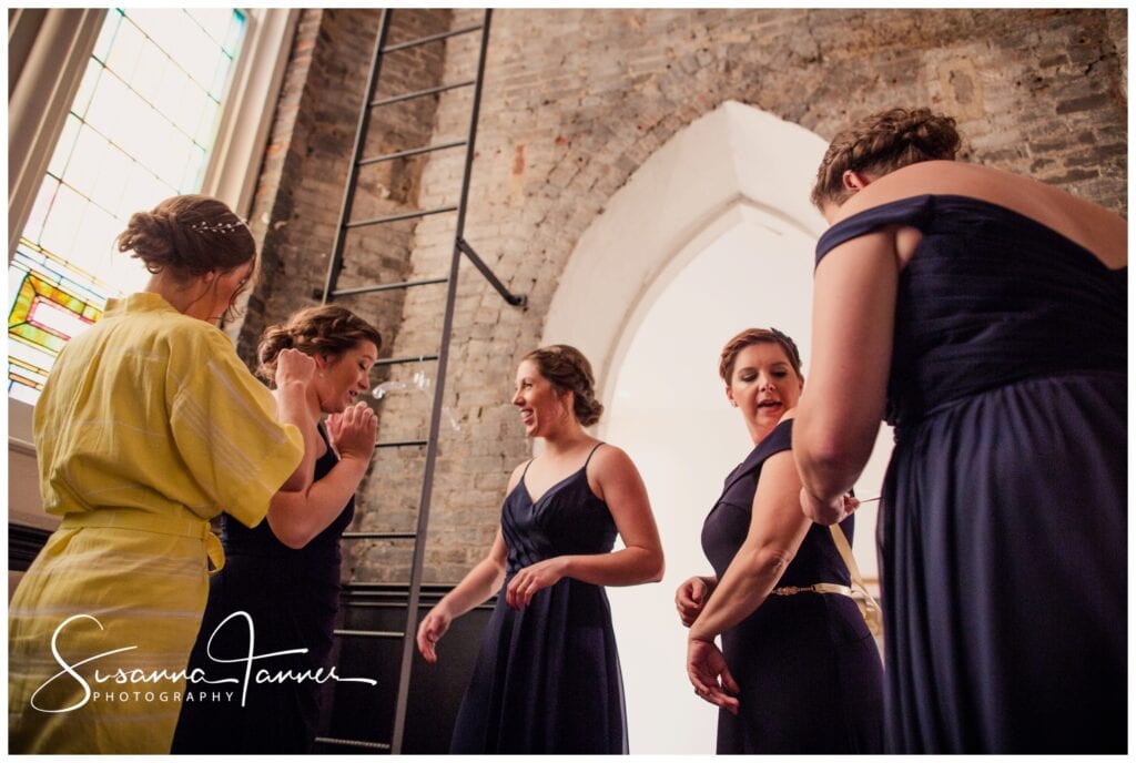 The Transept, Cincinnati OH wedding, bride helping bridesmaids while putting gowns on. 