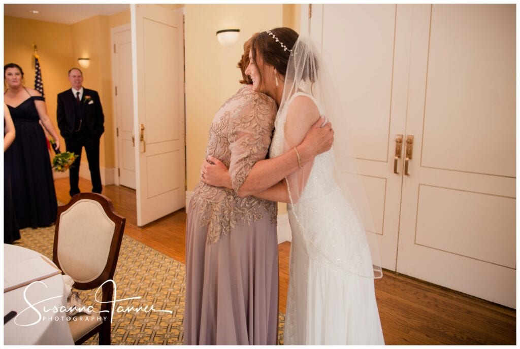 Taft Museum of Art, Cincinnati Ohio wedding, mother hugging bride after veil is on while father watches in background. 
