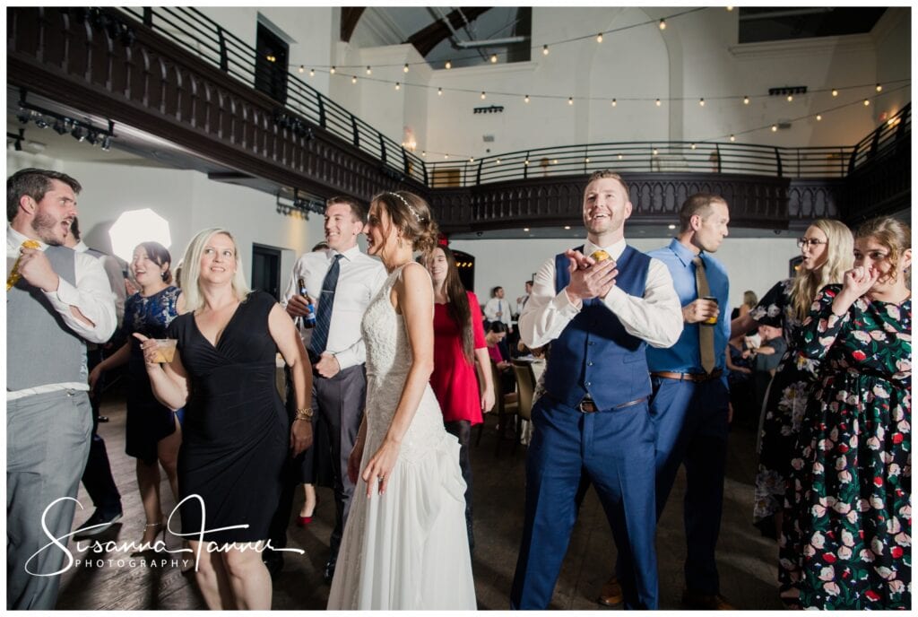 The Transept, Over-the-Rhine, Cincinnati Ohio wedding, group dancing with groom clapping his hands and smiling. 