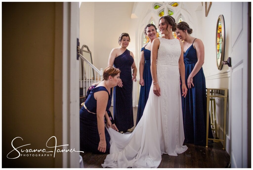 The Transept, Cincinnati OH wedding, bridesmaids gather around bride to adjust her dress. 