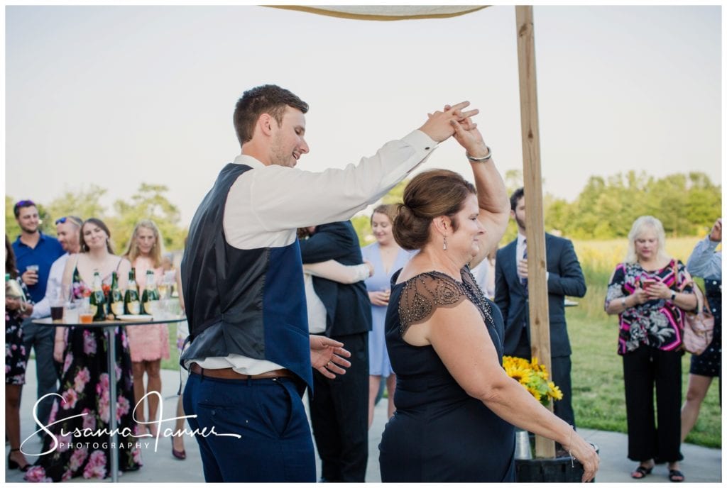 groom twirling mom during their dance