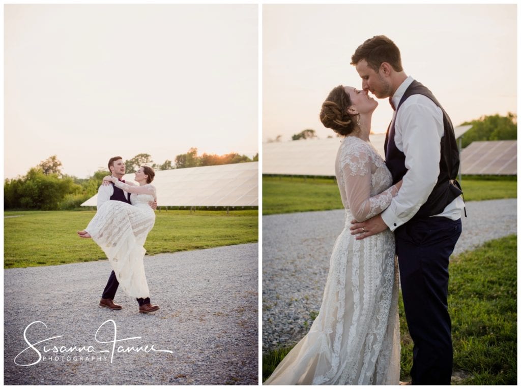 Groom carries barefoot bride across parking lot to a field of grass where they share a kiss at sunset
