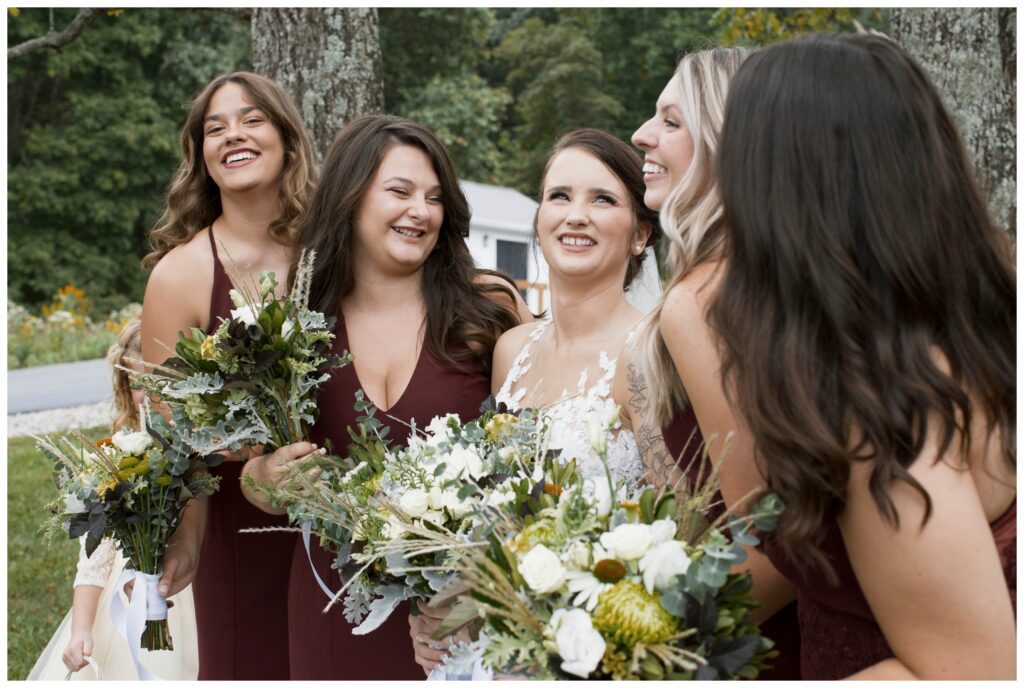 bridesmaids holding flowers and sharing a laugh