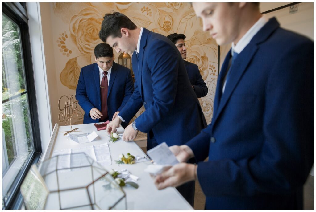 The Wilds Wedding Venue, Bloomington, Indiana, groomsmen folding pocket squares and boutonniers