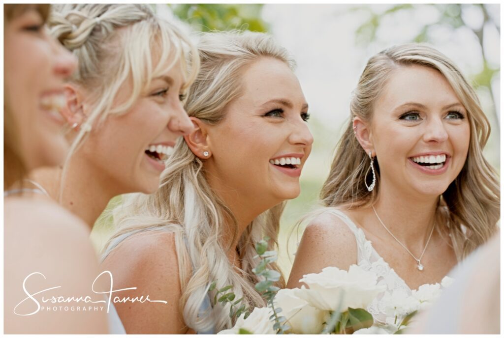 close up of bride and bridesmaids smiling and laughing, all have blond hair