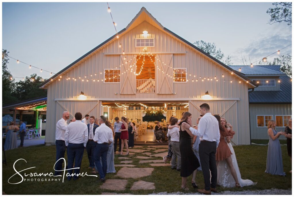 laurel mill barn wedding at night with outdoor lighting and people gathering.