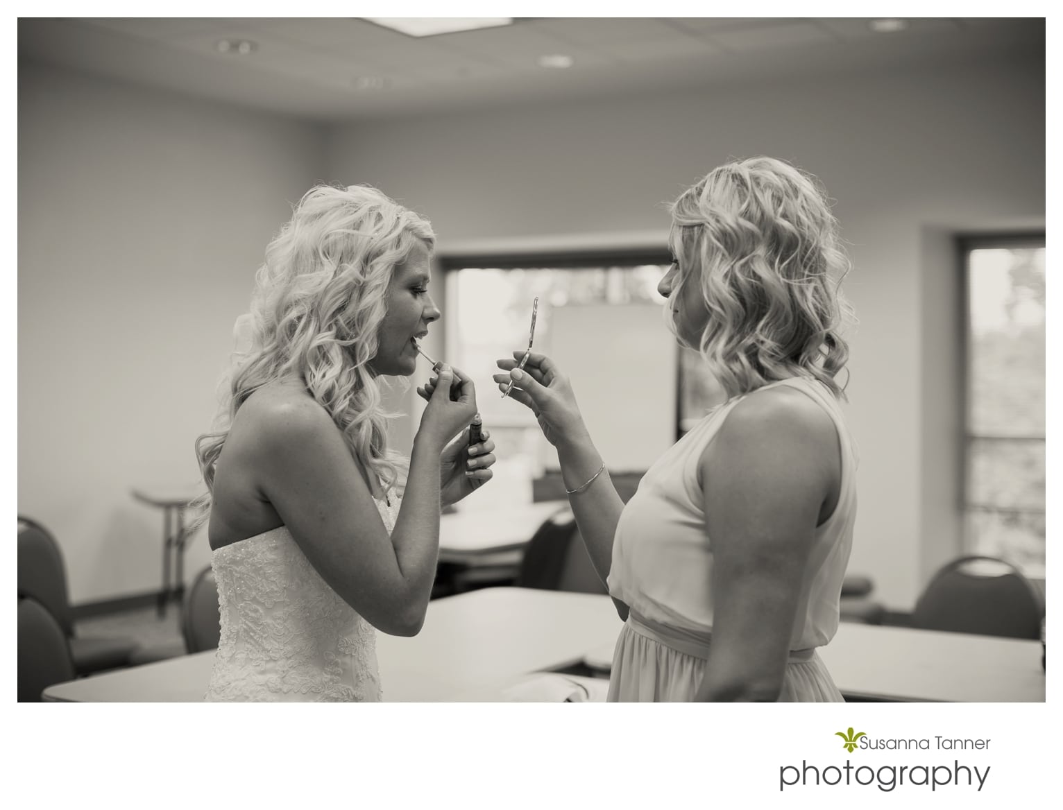 Indiana State Museum wedding photography, bride putting on lip gloss while bridesmaid holds up a mirror for her
