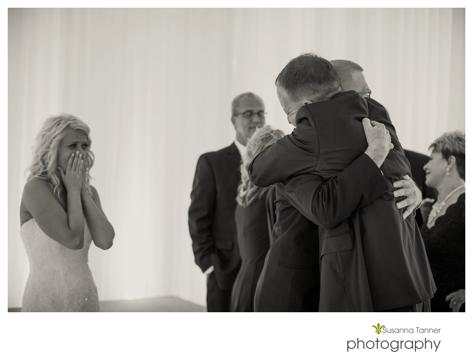 Indiana State Museum wedding photography, groom and father of bride hug while bride watches with tears in eyes