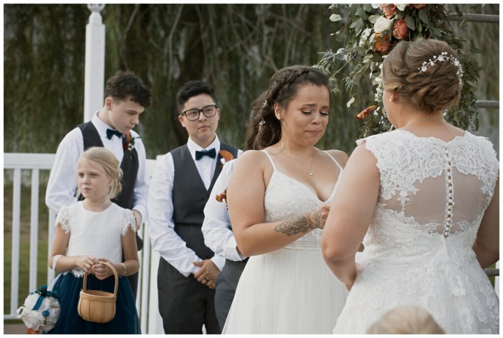 gay wedding, west central Ohio, bride #2 begins crying during vows while wedding party looks on