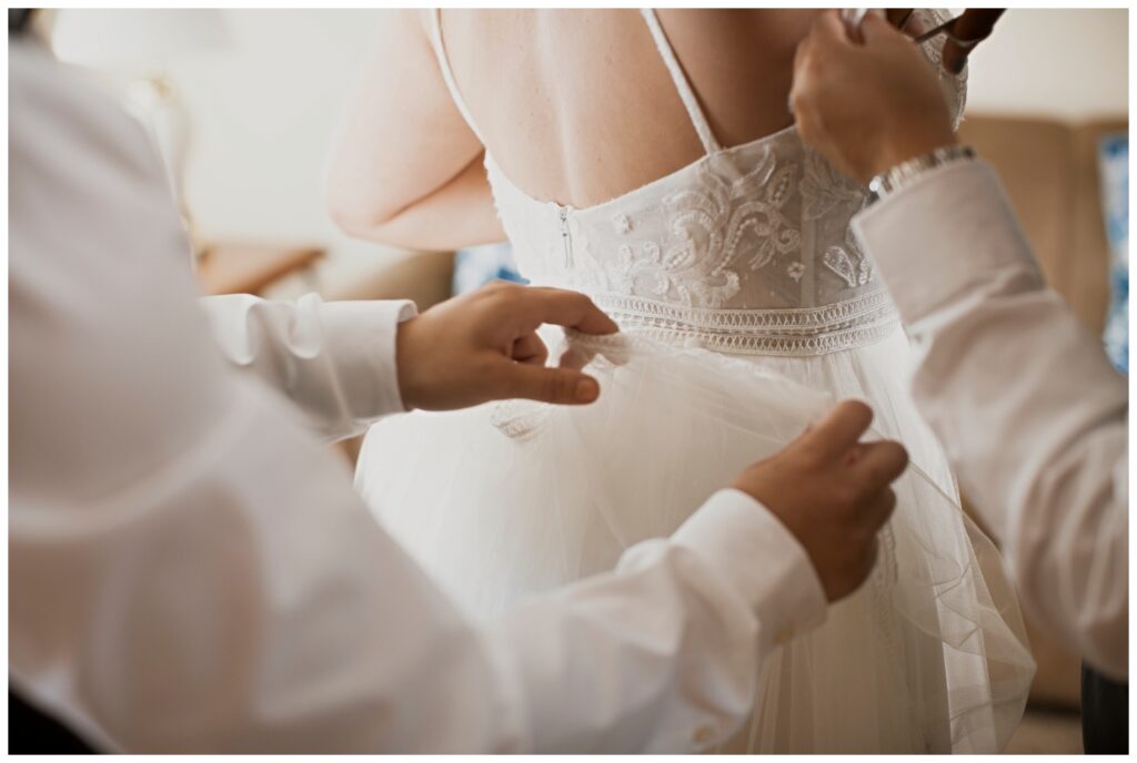 Gay wedding, west central Ohio, groomspeople adjusting bride's wedding dress