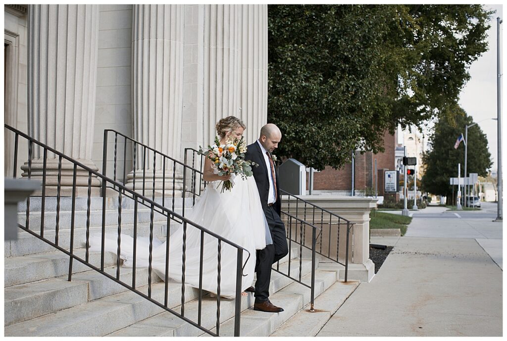 outdoor wedding venue, Richmond, IN, bride and groom walk down steps to leave church